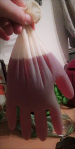 Gruselhand bestehend aus einem Gummihandschuh gefüllt mit Rotwein